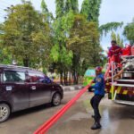 Sedimen Lumpur Meluber, Disdamkar Lakukan Penyemprotan Jalan