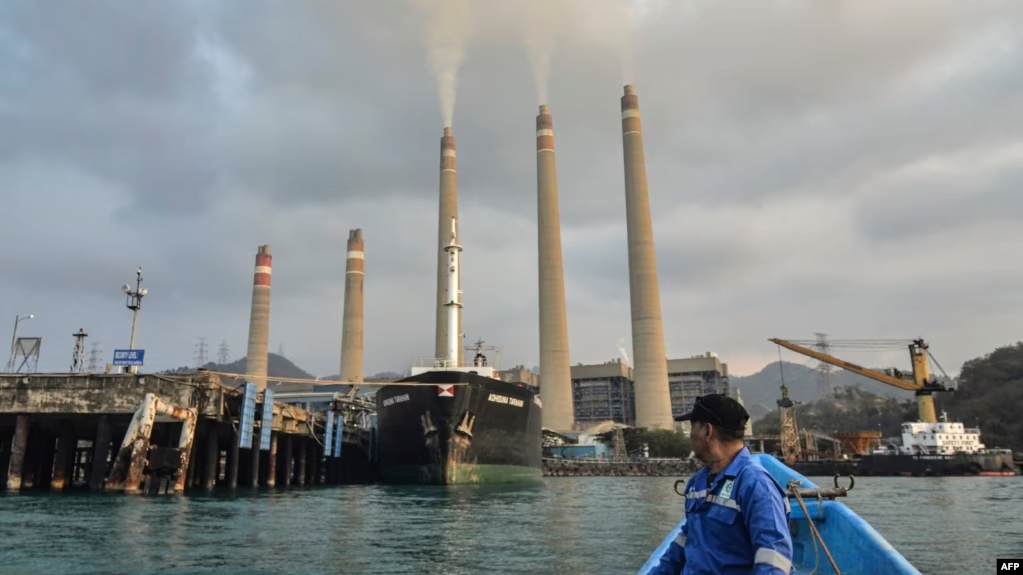 Seorang nelayan sedang mengamati pembangkit listrik tenaga batu bara (PLTN) Suralaya di Cilegon, provinsi Banten, 31 Oktober 2023. (Ronald SIAGIAN / AFP)