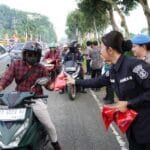 Polwan Polda Kaltim Turun ke Jalan, Bagikan Bendera Merah Putih Sambut HUT RI ke-80